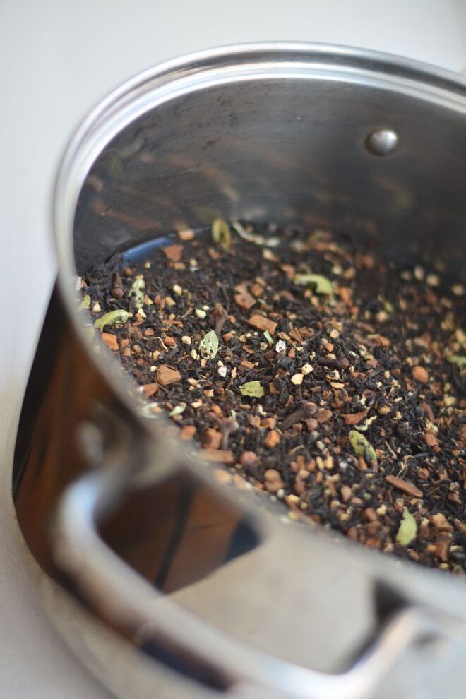 homemade masala chai concentrate in a pan, simmering on stove