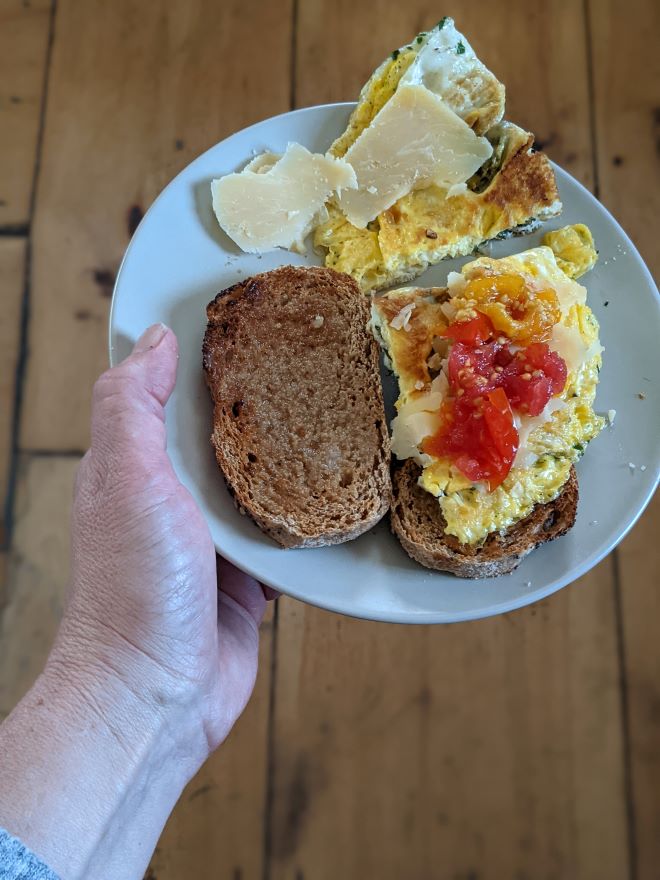 egg sandwich on fresh milled sourdough bread, toasted with cheese and fermented tomatoes