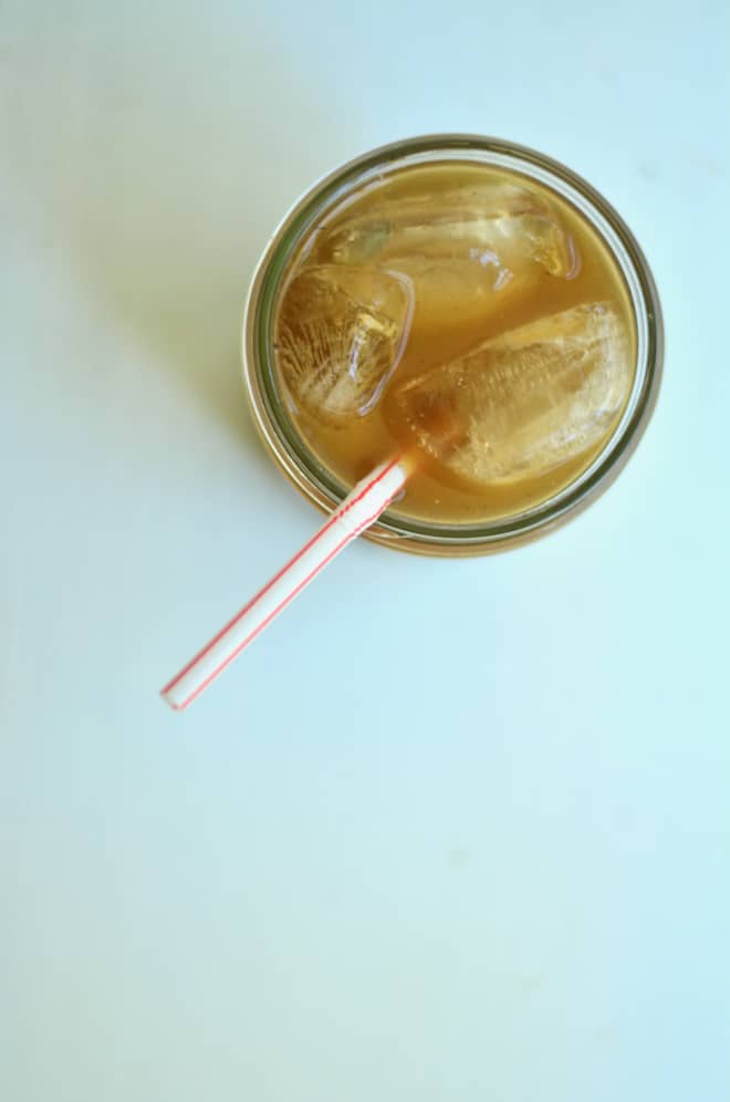 Cold, icy cup of homemade Dr Pepper soda with a straw in a jar.