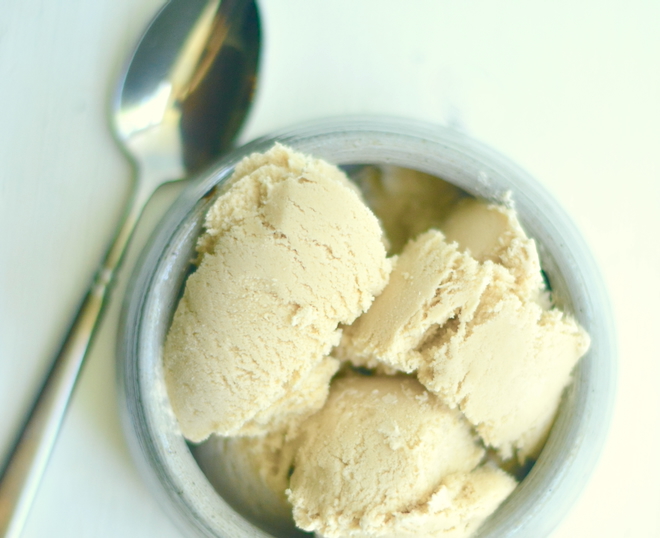 a spoon lies beside a pottery bowl filled with ice cream