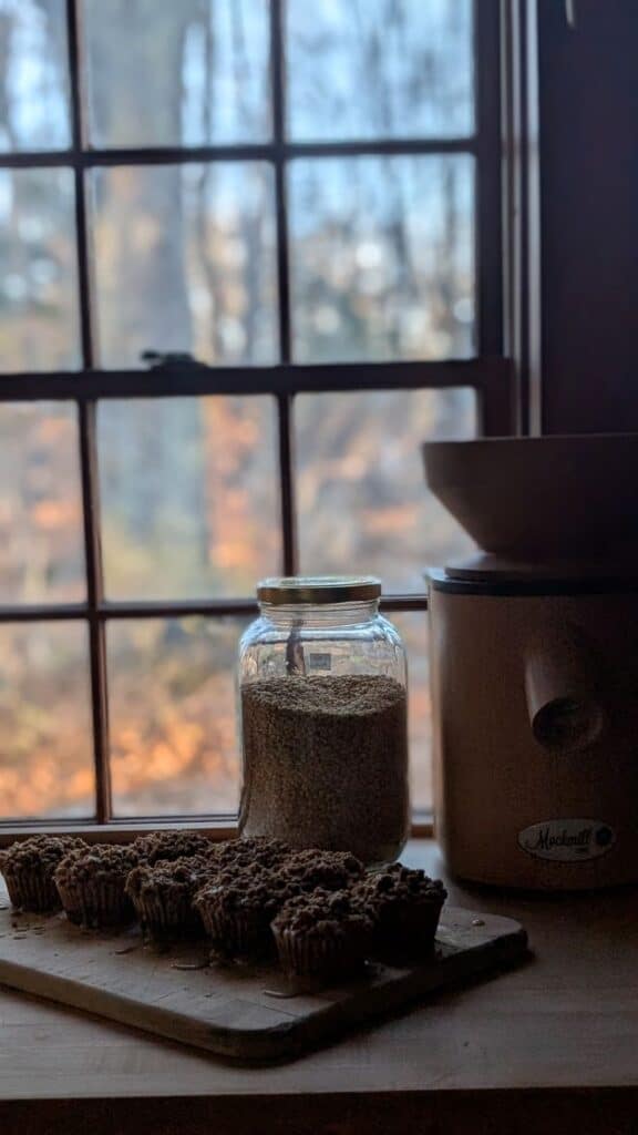muffins in window with grain mill and wheat berries, fresh milled flour