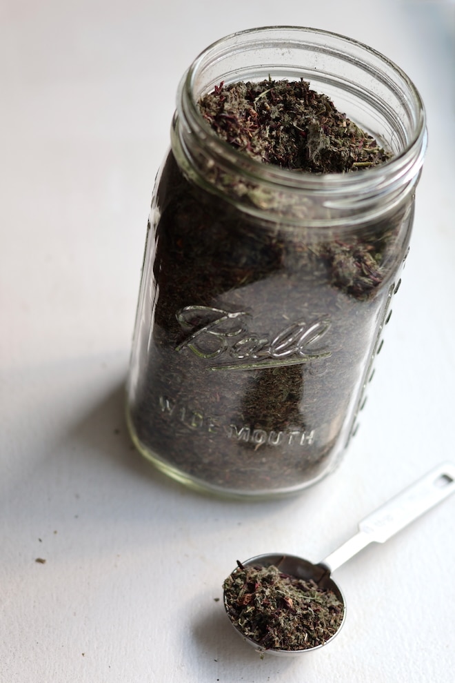 a wide mouth mason jar holding a loose leaf tea blend with hibiscus
