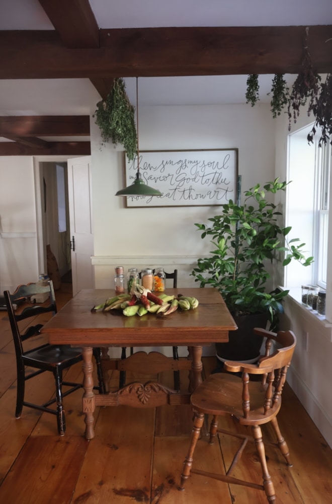 culinary herbs hang to dry in old fashioned kitchen and jars of herbs sit on table