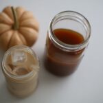 iced pumpkin chai latte with a jar of pumpkin chai concentrate with a pumpkin in background blog