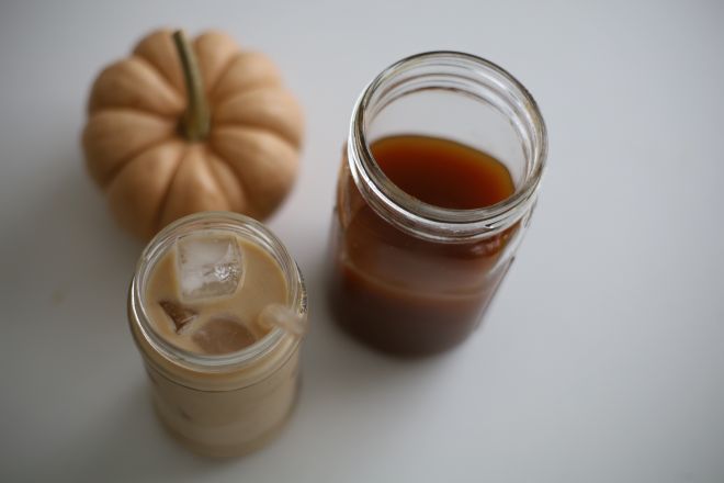 iced pumpkin chai latte with a jar of pumpkin chai concentrate with a pumpkin in background blog