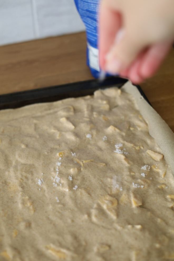 sprinkling salt onto raw cracker batter made from sourdough and einkorn wheat berries